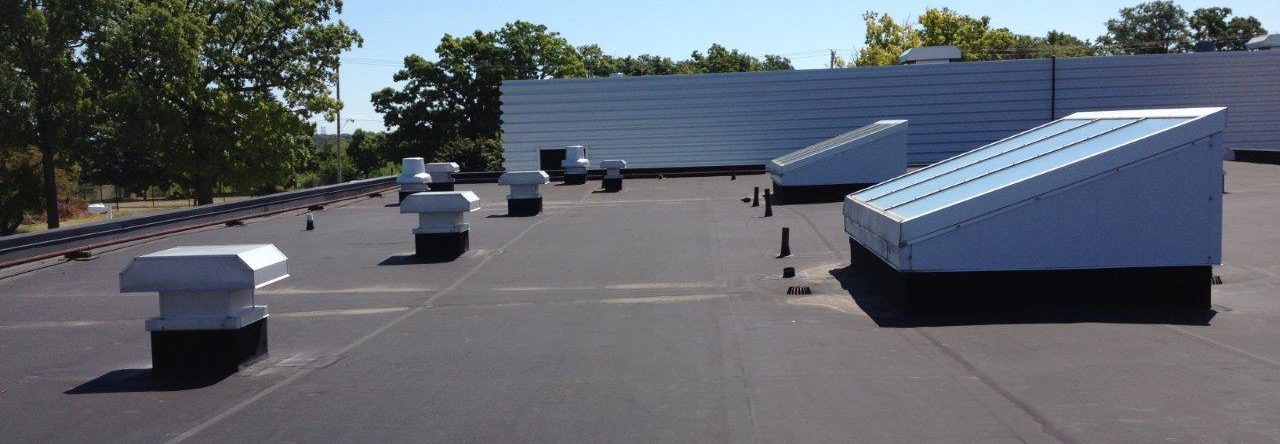Completed low-slope roof with rooftop vents and skylights